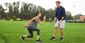 Personal trainer coaching movement quality and control in strength training session